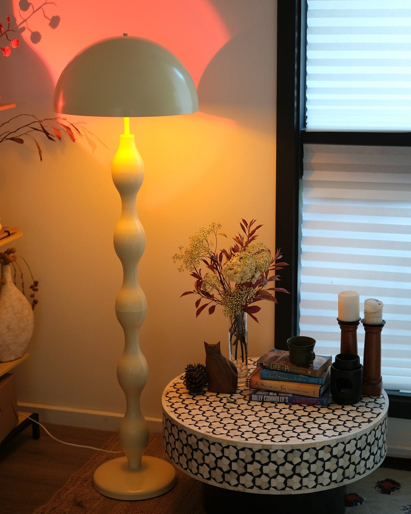 Decorative table with candles and a vase next to a Retro modern mushroom lamp with wavy sculptural base in butter yellow