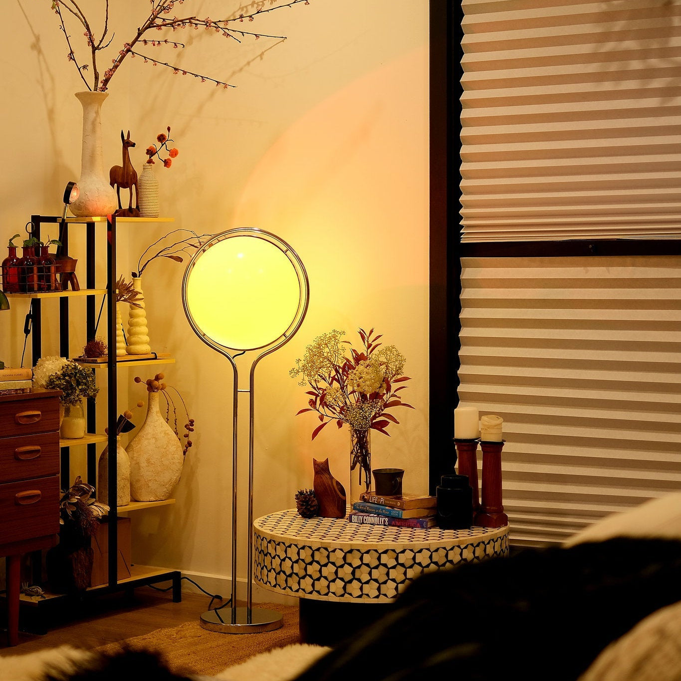 Living room with Garreau Globe Floor Lamp Bauhaus Replica Chrome Stand, shelves, and decorative items.