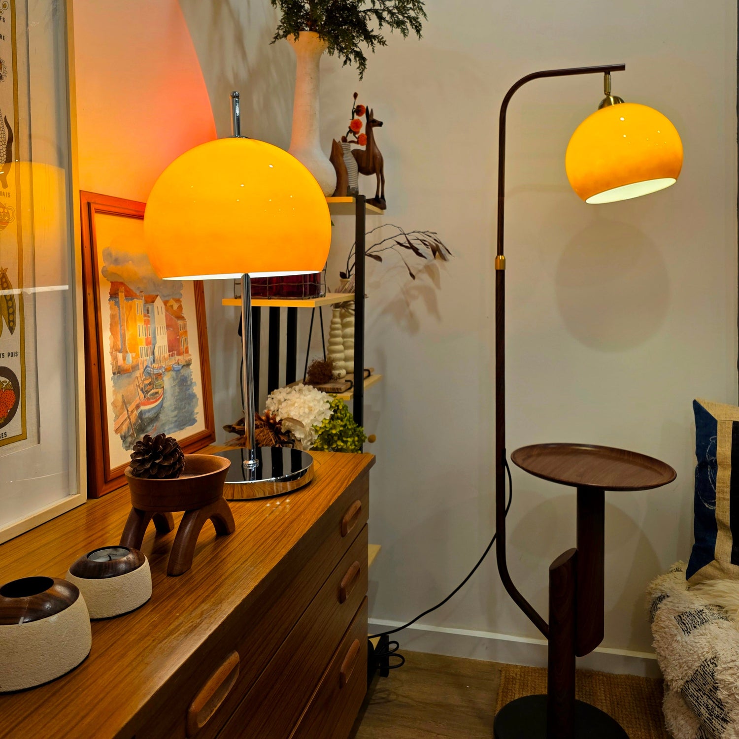 Orange Mushroom lampshades on a wooden dresser and floor lamp in a room with decor elements.