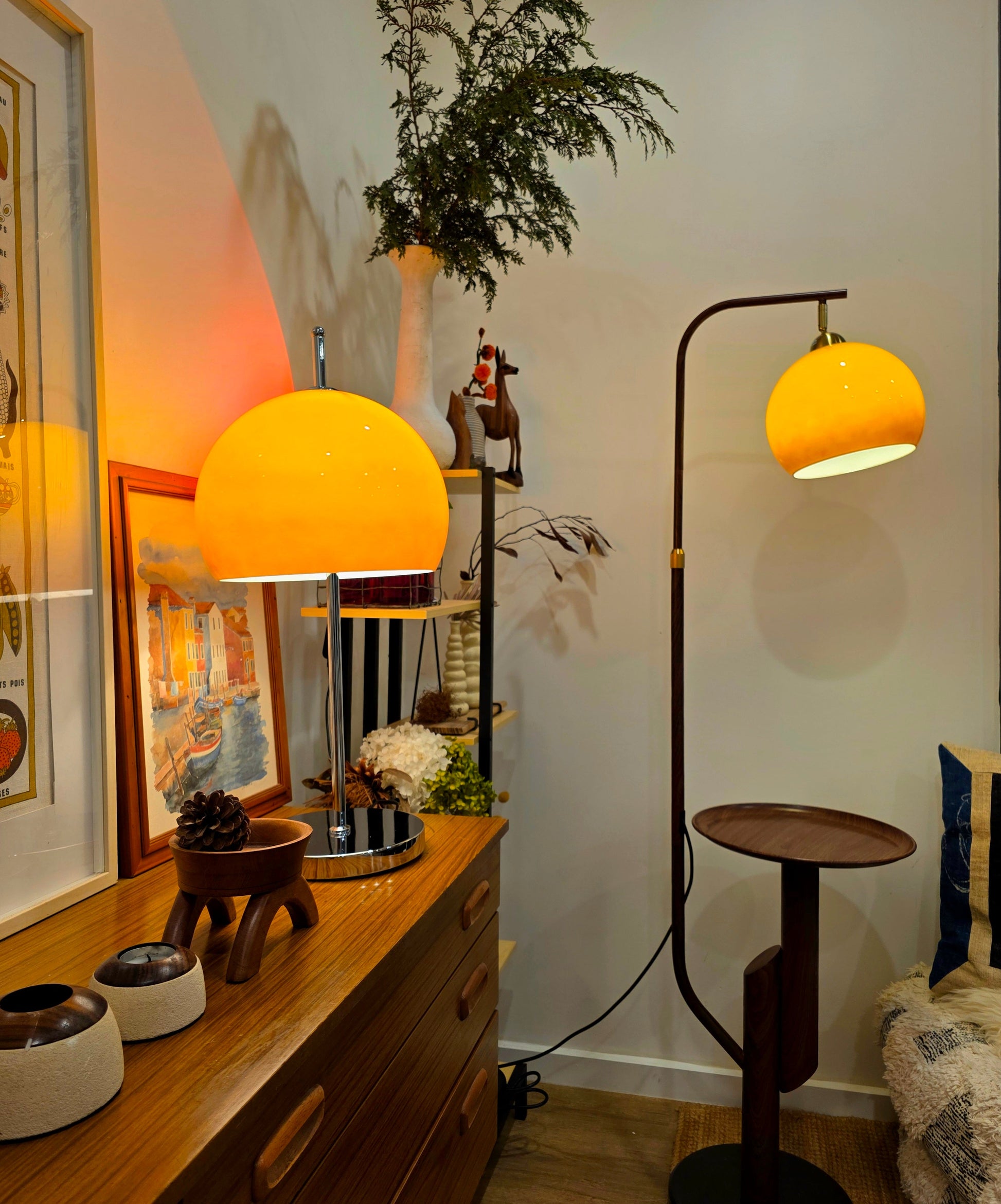 Orange Mushroom lampshades on a wooden dresser and floor lamp in a room with decor elements.