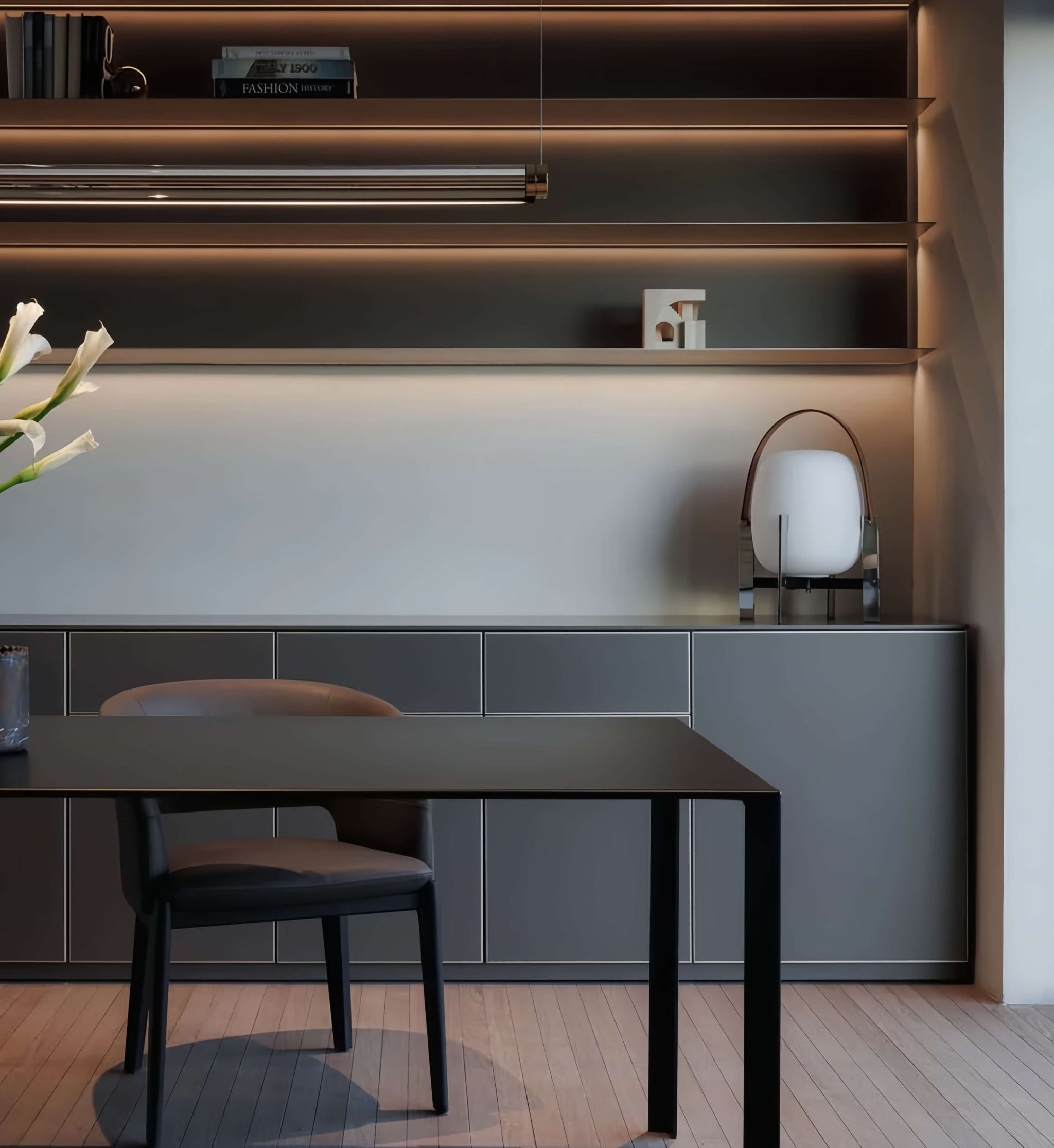 Modern interior with a dining table and chairs against a wall with shelves and Alix Cesta Metálica Basket Lamp with chrome legs and frosted glass