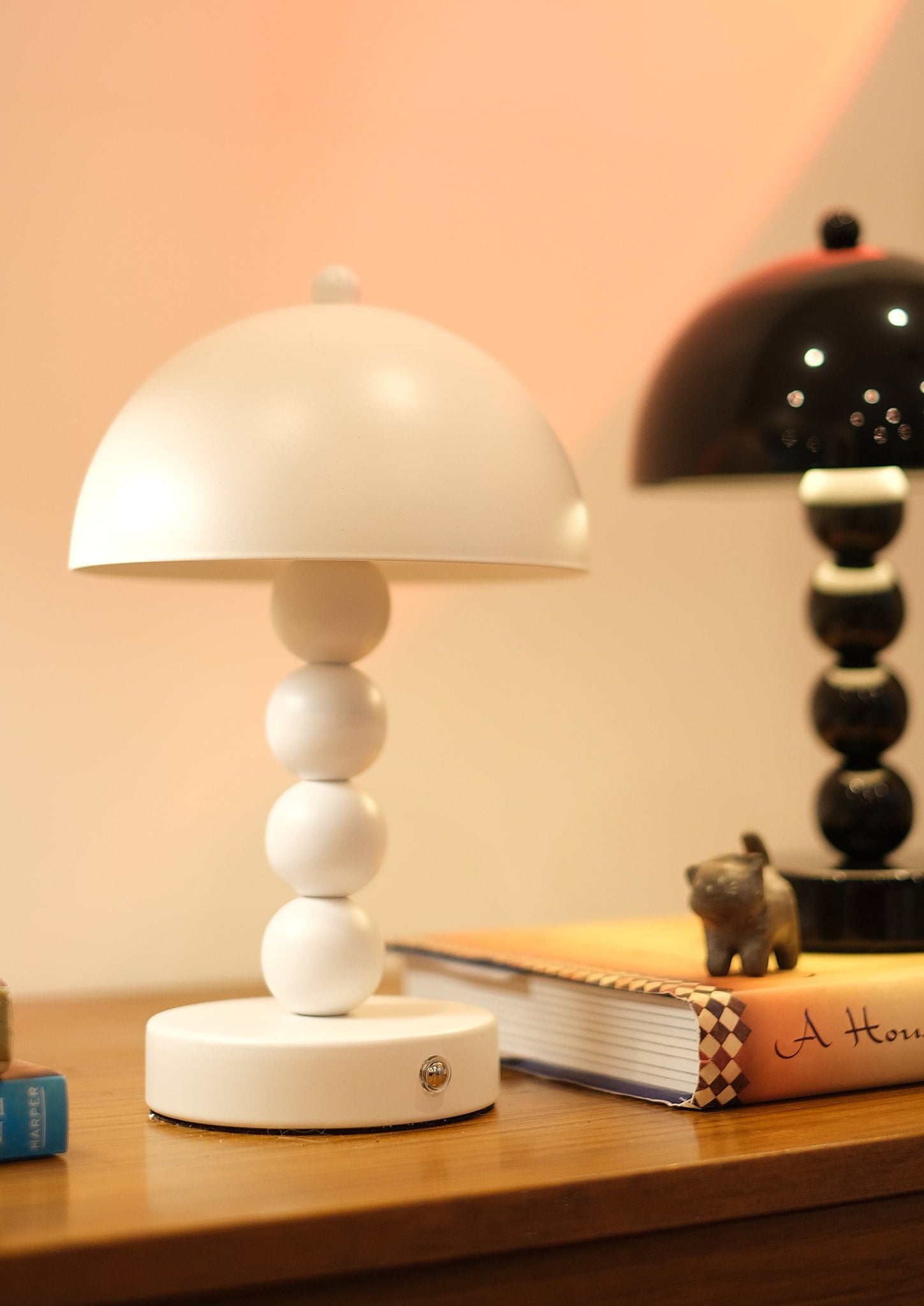 Bobbi Portable LED Table Lamp in white lacquer finish on bedside table on a wooden surface with a blurred background