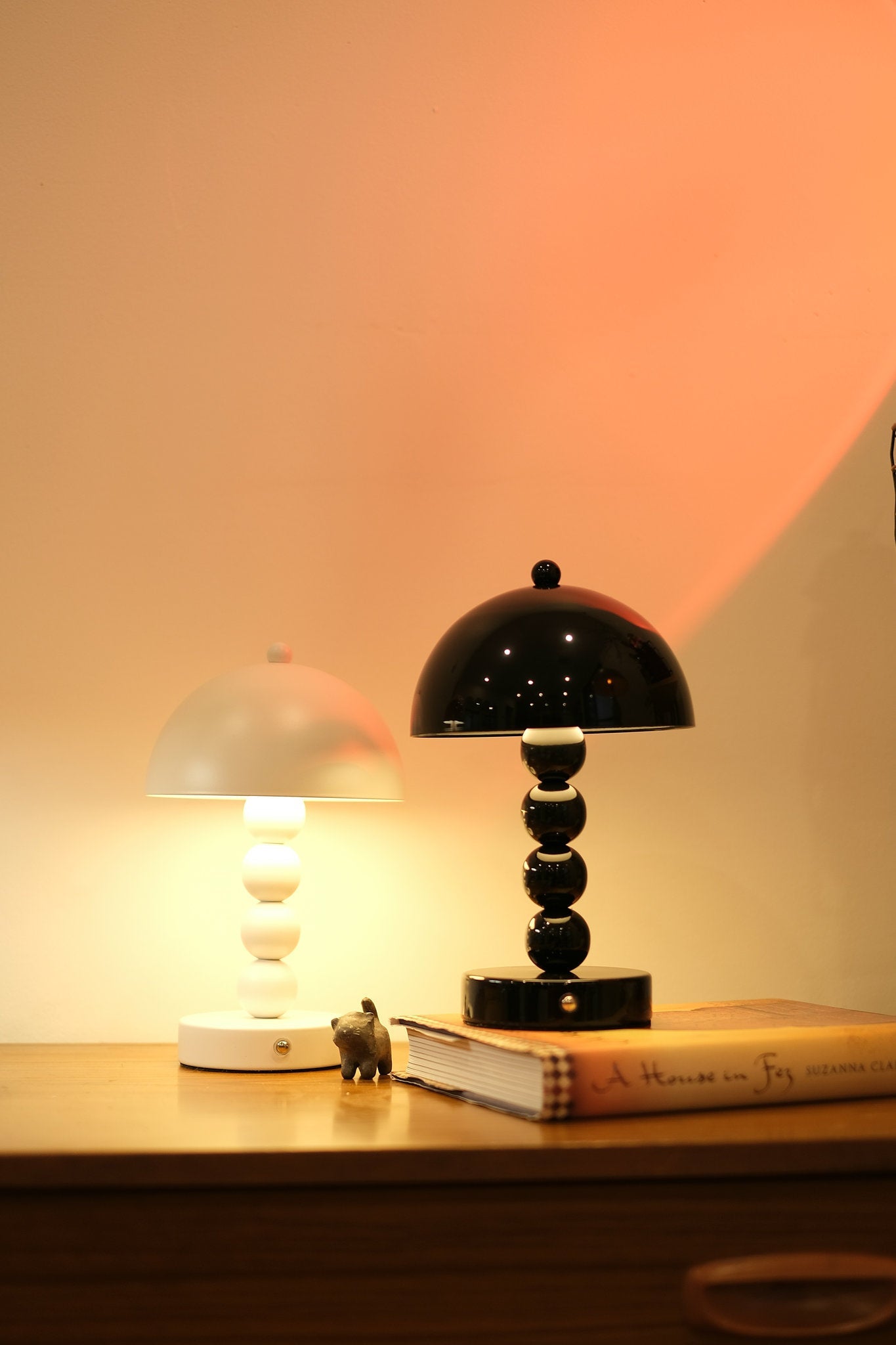 Touch dimmable Bobbi lamp in Nordic minimalist décor on a wooden surface with a soft pink background