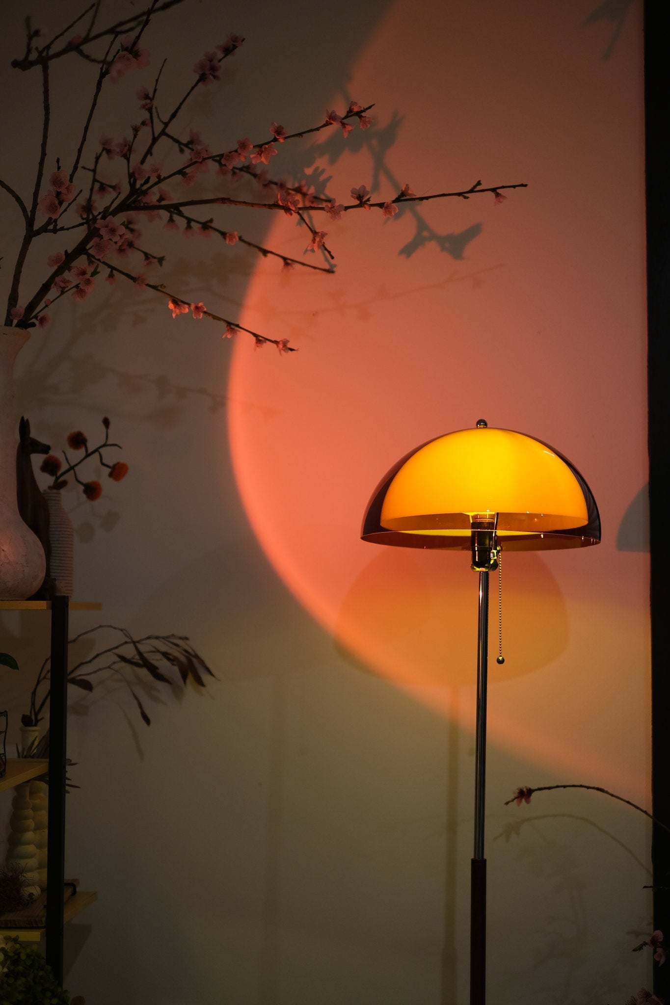 Coby+ Mushroom Bauhaus Floor Lamp Orange with Pull Chain Yellow lamp casting a shadow on a wall with floral branches.