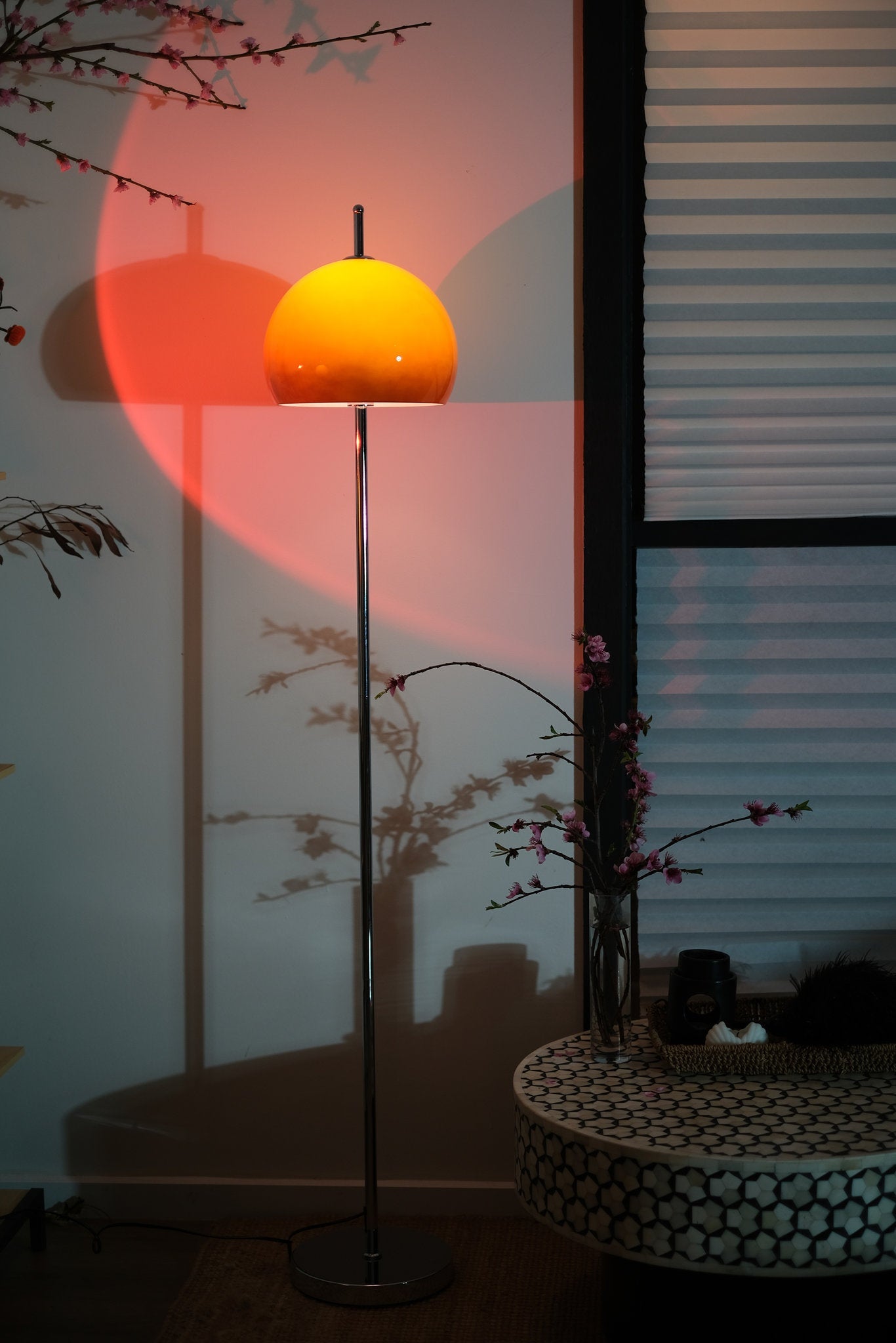 Olivia Mushroom Bauhaus Yellow floor lamp casting a shadow on a wall with a pinkish hue.