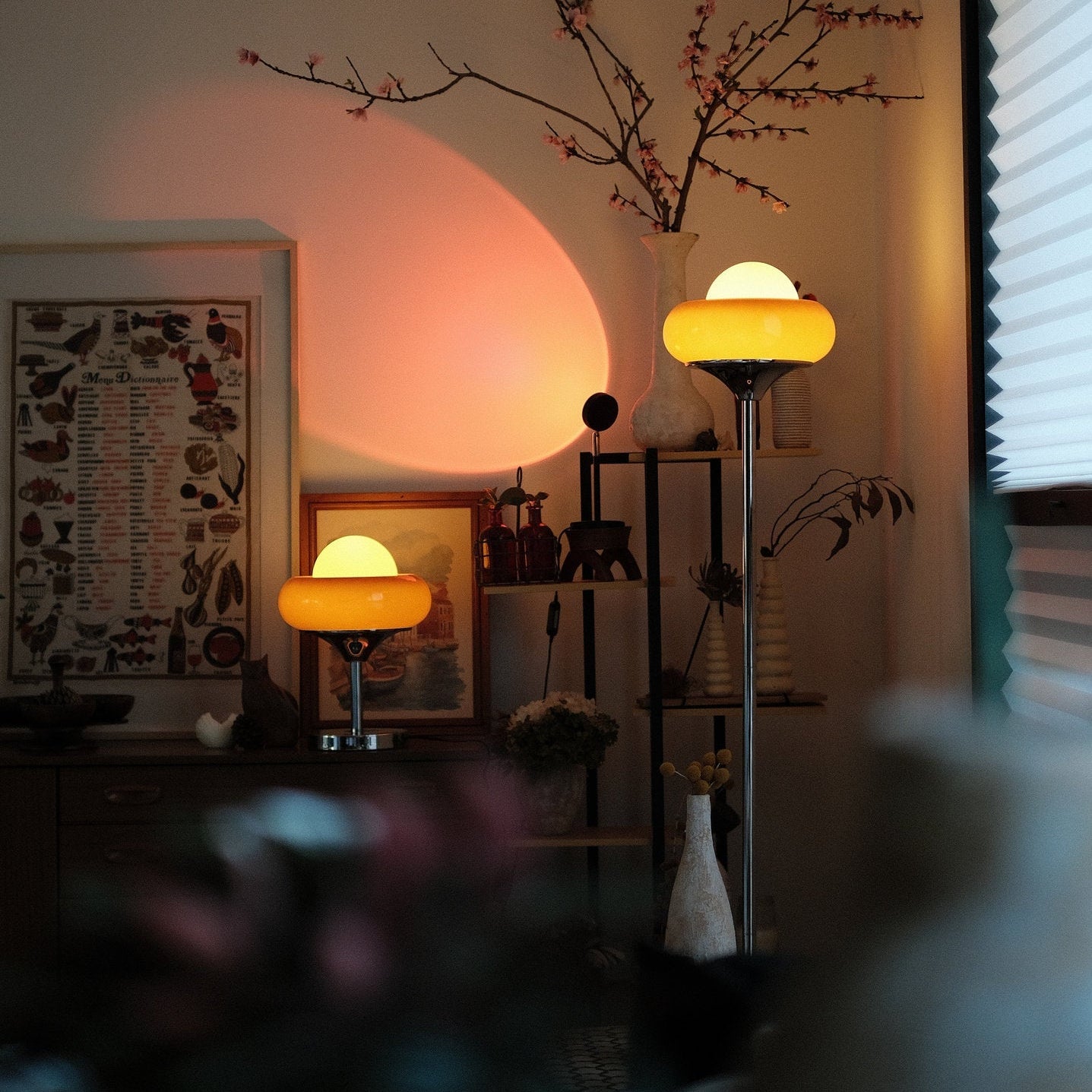 Living room with Avery Egg Tart Floor and Table Lamp Set with curved glass dome shades in orange and white and decorative items on a shelf.