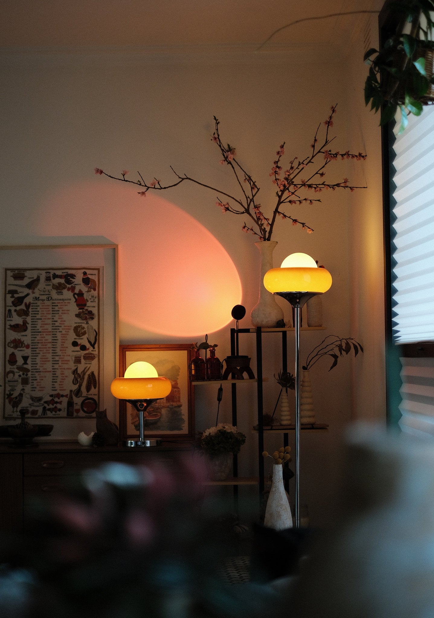 Living room with Avery Egg Tart Floor and Table Lamp Set with curved glass dome shades in orange and white and decorative items on a shelf.