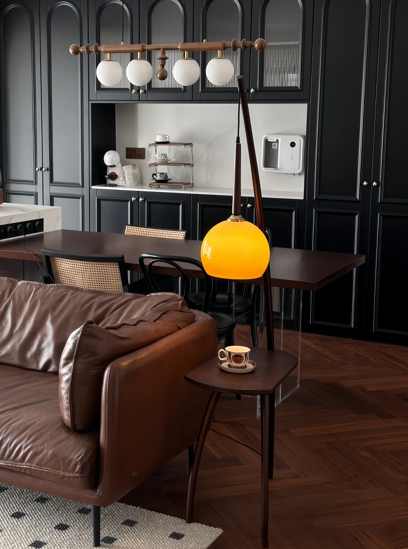 Modern kitchen with dark cabinets, a brown sofa, and a Domus Pollo Floor Lamp with walnut stand and built-in side table