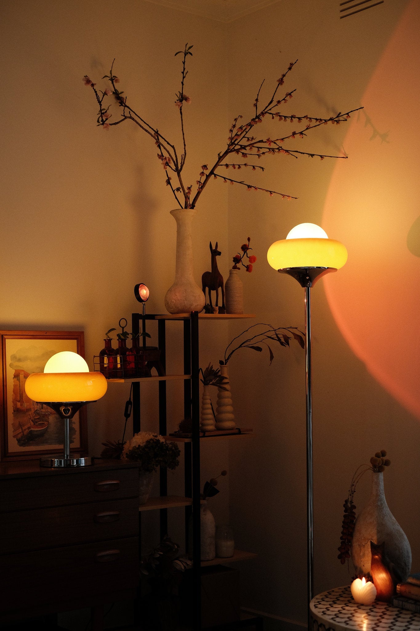 Nostalgic interior scene with vintage Bauhaus-inspired Egg Tart Lamp set casting soft ambient glow in living room décor items on a shelf.