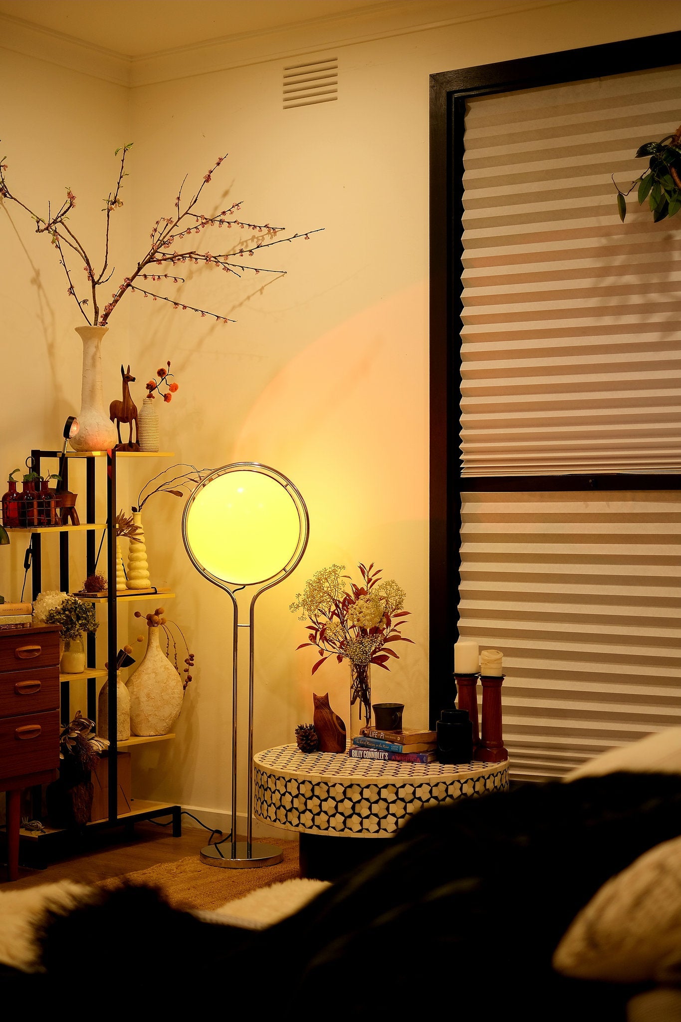 Living room with Garreau Globe Floor Lamp Bauhaus Replica Chrome Stand, shelves, and decorative items.