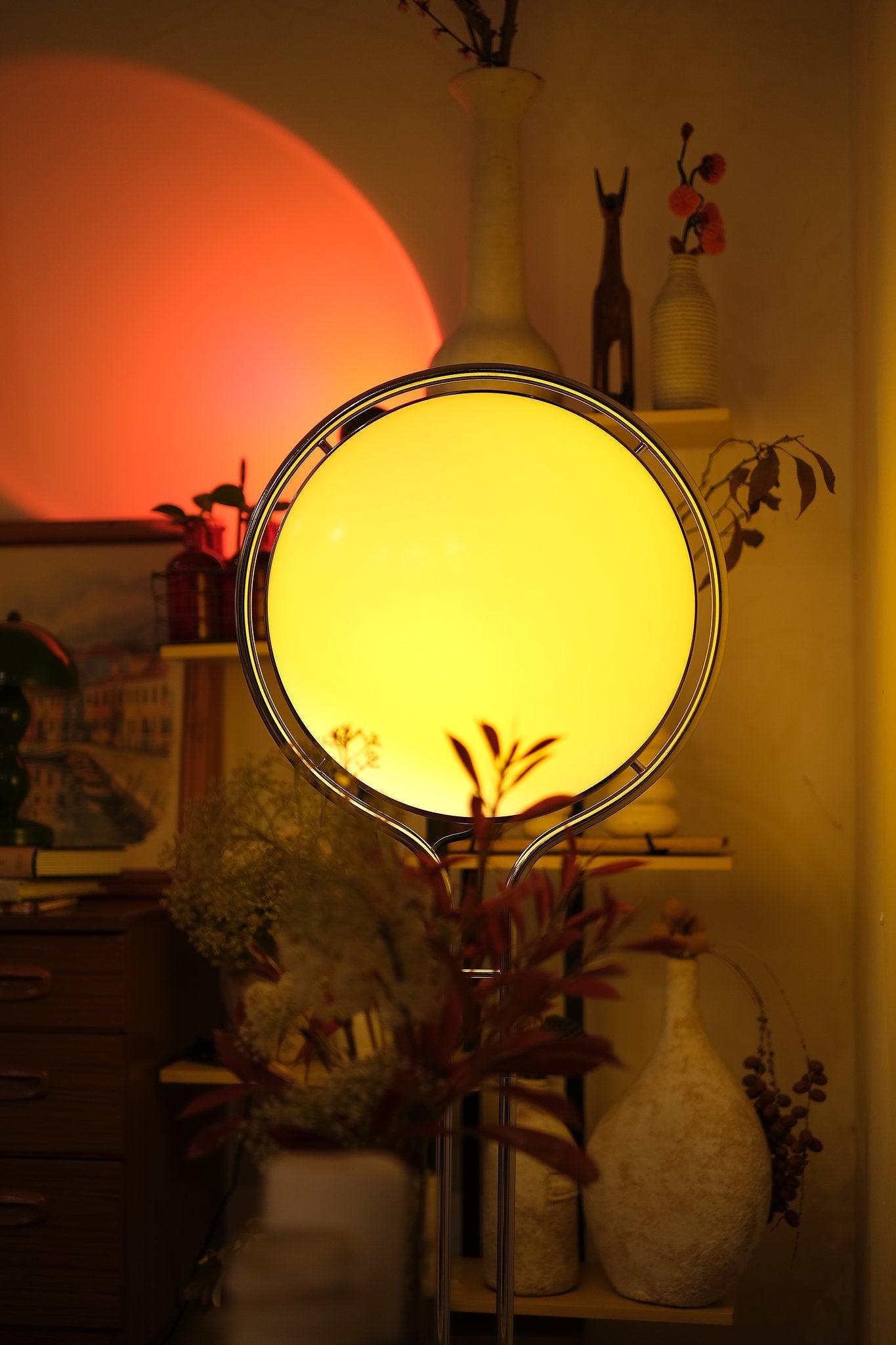 Round lamp emitting a warm glow in a softly lit room with decorative items. Garreau Globe Floor Lamp Bauhaus Replica Chrome Stand