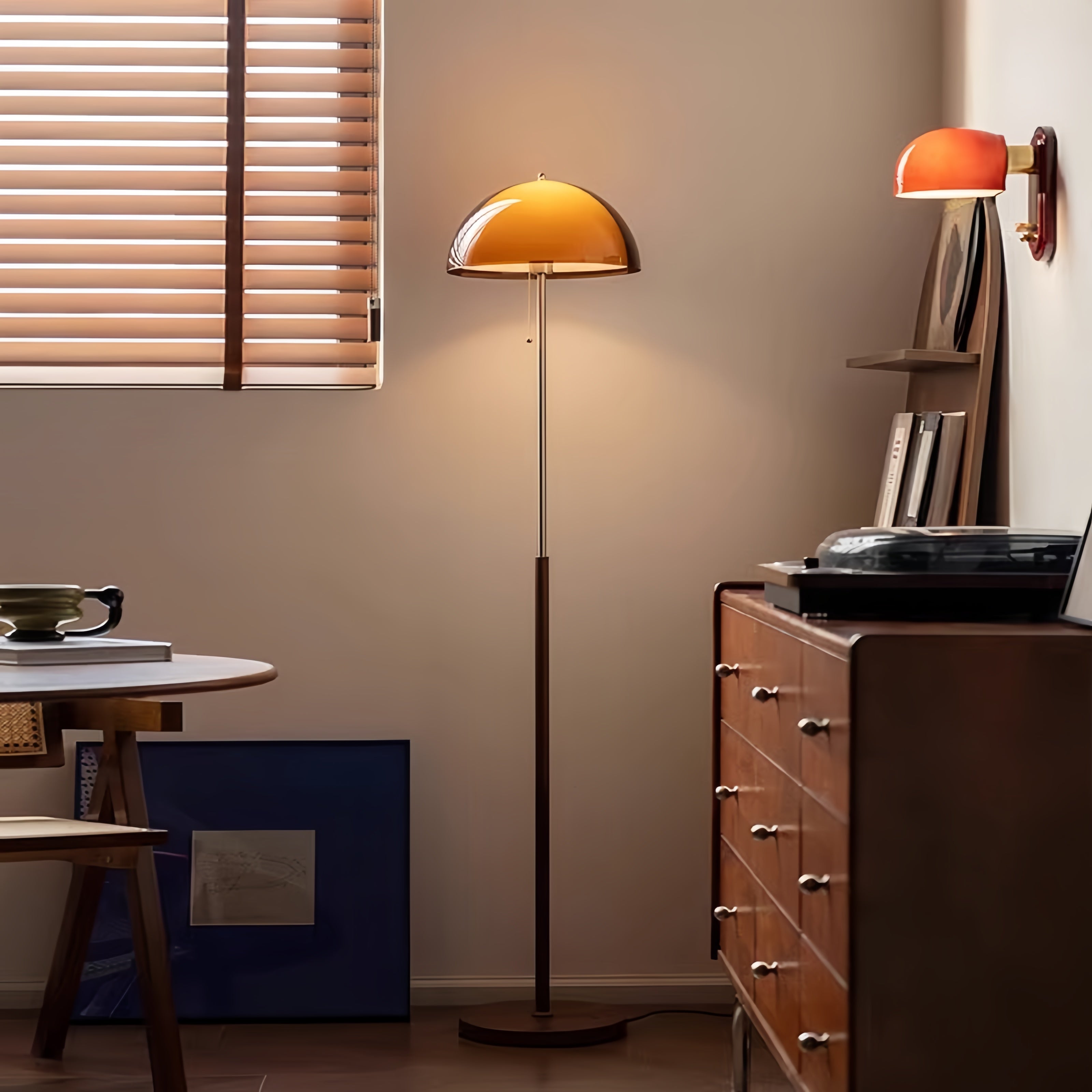 Modern interior with a standing lamp Coby+ Mushroom Bauhaus Floor Lamp Orange with Pull Chain and wall sconce in a room with wooden furniture and a window.