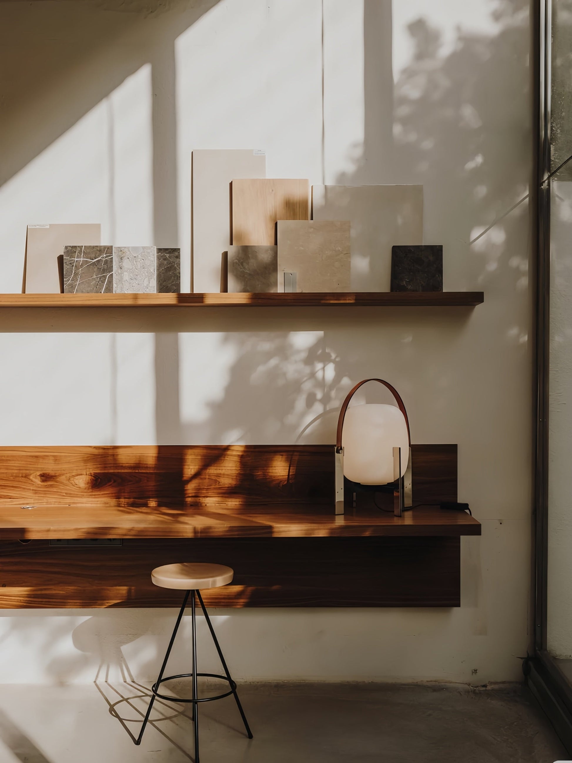 Wooden shelves with Alix Cesta Metálica Basket Lamp with chrome legs and frosted glass and a stool in a well-lit room.