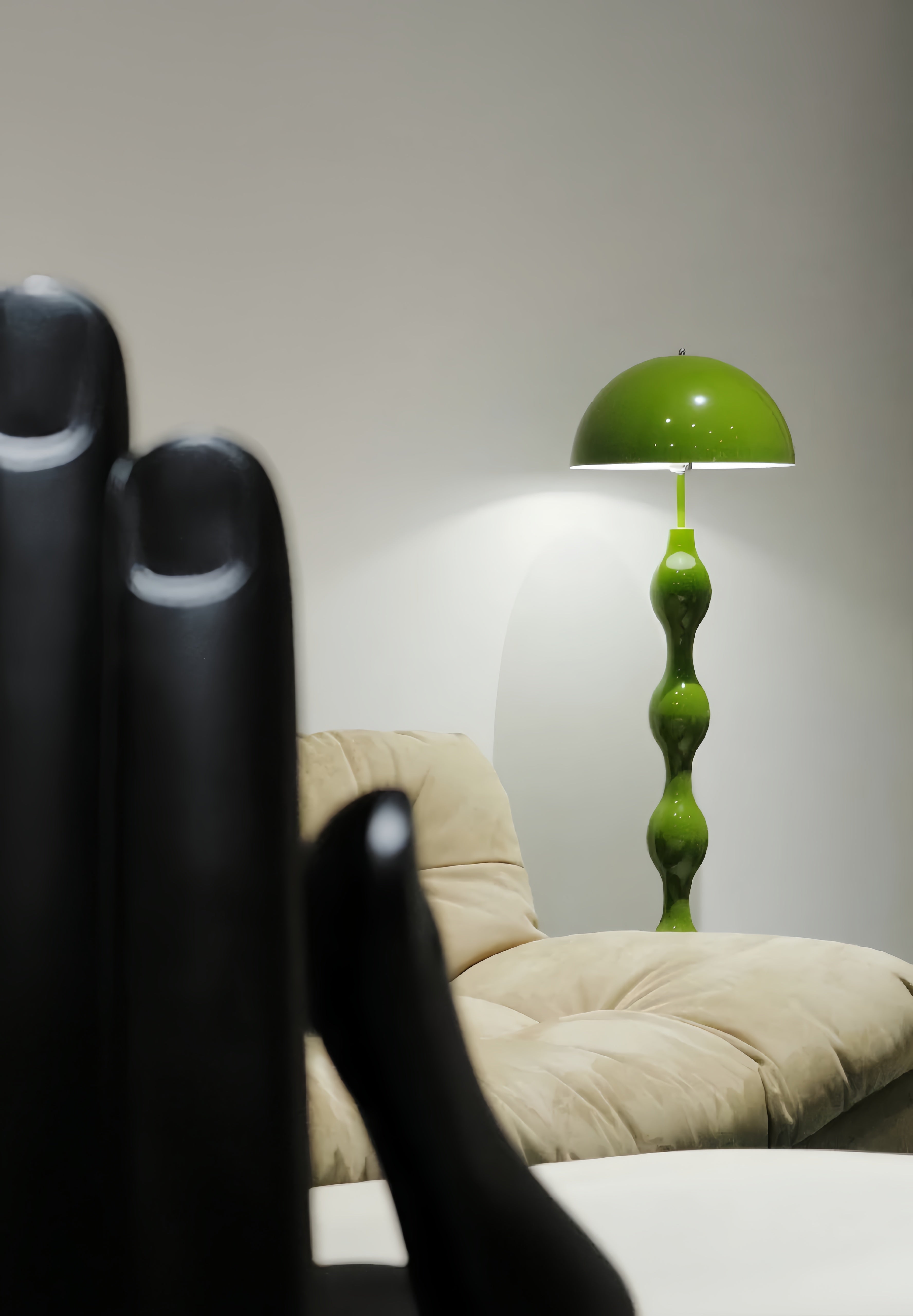 Dori Wavy Mushroom Floor Lamp in Olive Green with sculptural wavy base with a unique design in a room with a beige sofa.
